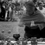 An indigenous woman performs a ritual with an audience watching closely in Mexico.