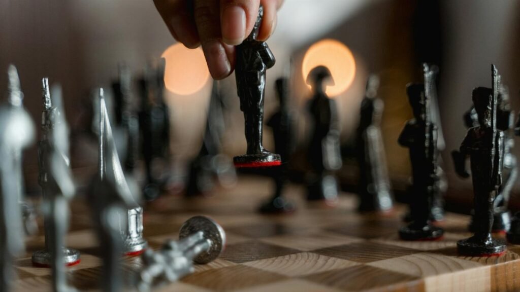 Hand placing unique chess piece on board, evoking strategy and intelligence.