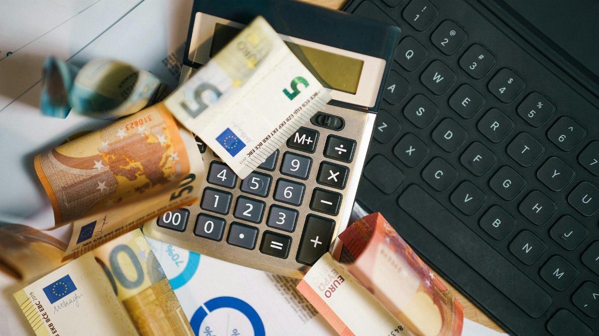 A financial setup featuring euro banknotes, a calculator, and a laptop keyboard for business analysis.