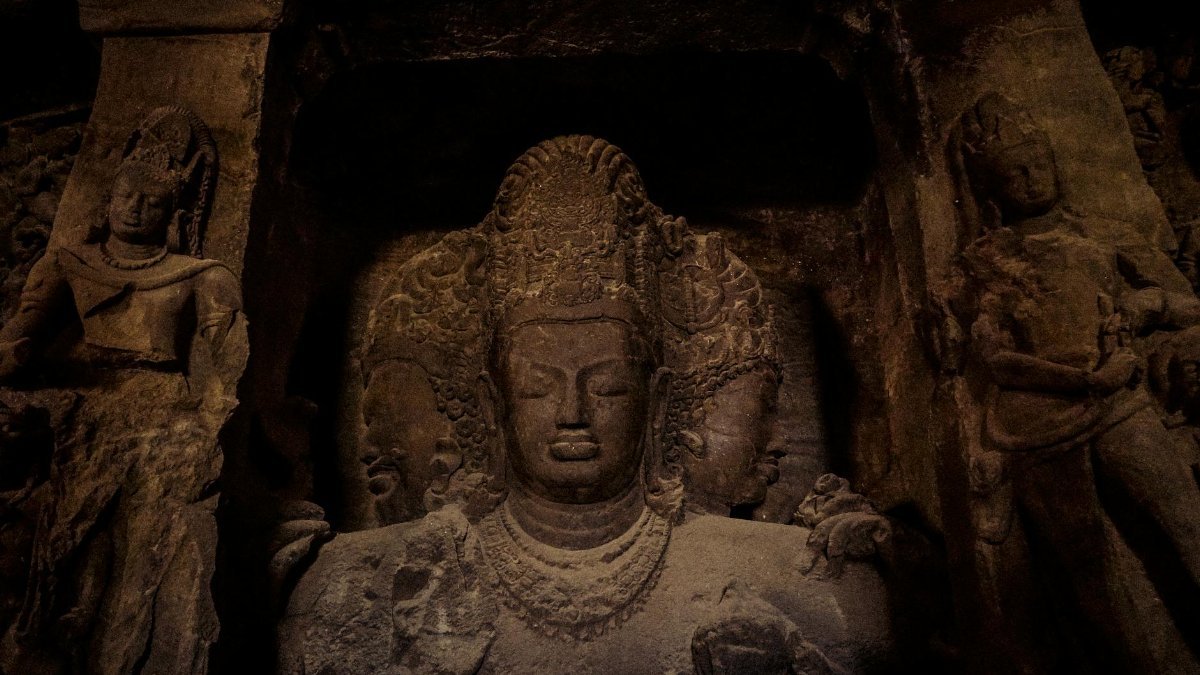 Ancient stone carvings of Hindu deities at the Elephanta Caves, a UNESCO World Heritage Site near Mumbai, India.