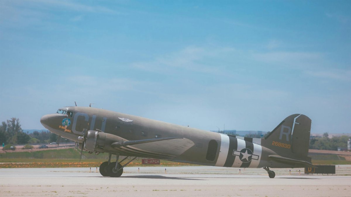 World War II military aircraft on runway during daytime airshow under clear blue sky.