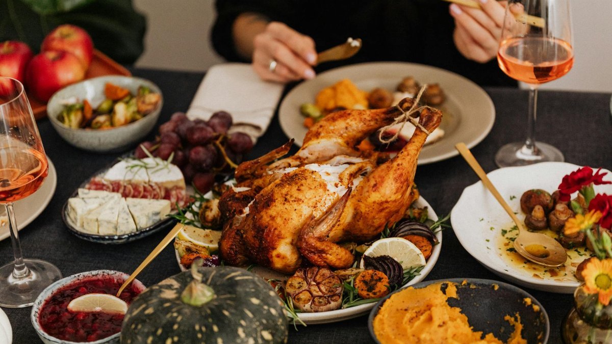 A festive Thanksgiving dinner spread featuring a golden roasted turkey, vegetables, and wine, perfect for holiday dining.