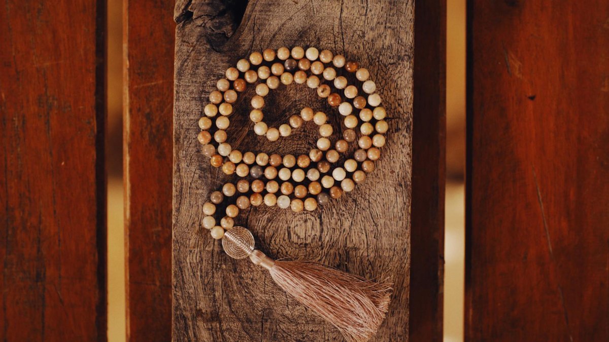 Wooden prayer beads arranged on rustic wood, conveying meditation.