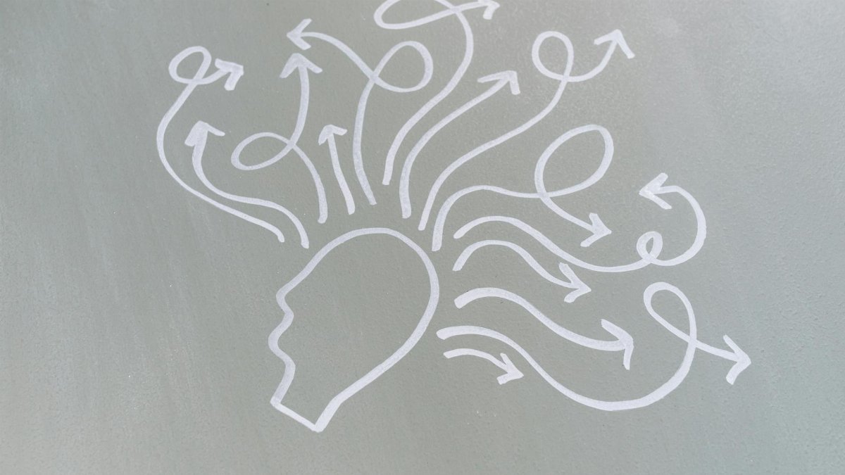 Chalk drawing of a head with swirling arrows represents mental activity and thought process.