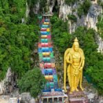 Aerial view of the vibrant Batu Caves and Lord Murugan statue in Selangor, Malaysia.