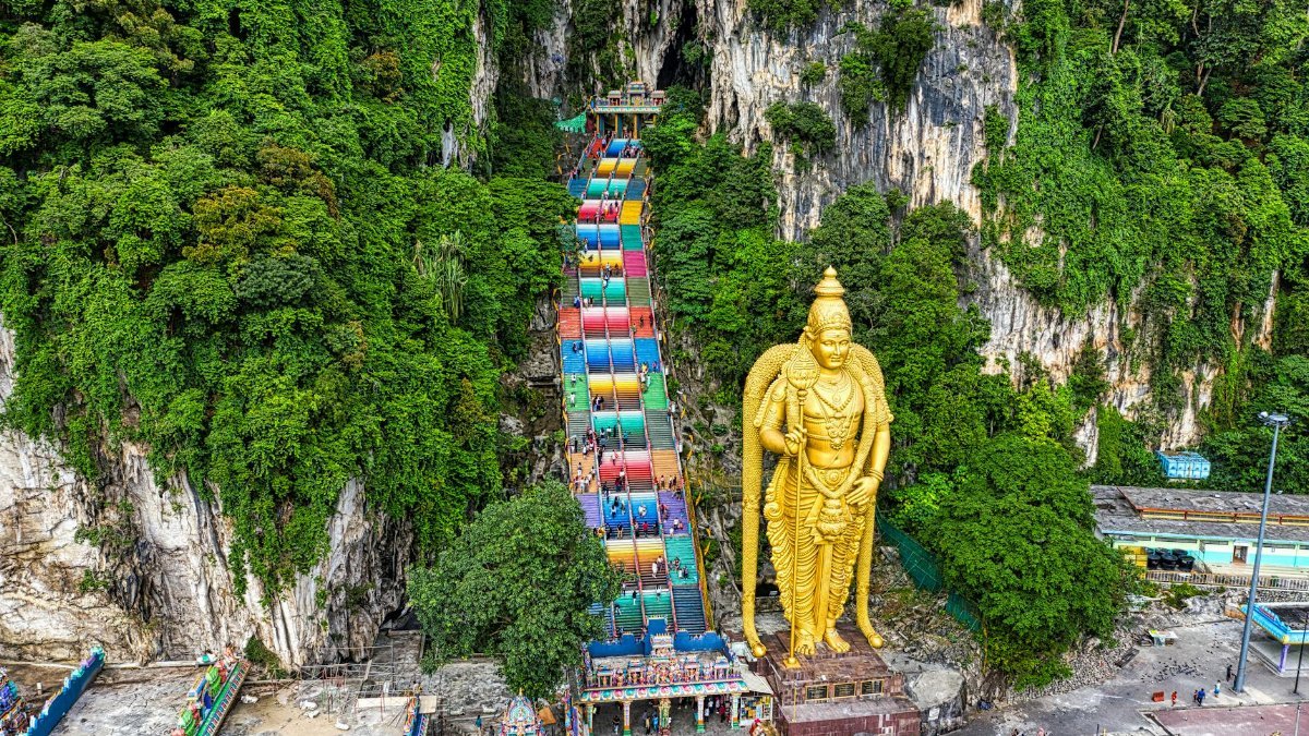 Aerial view of the vibrant Batu Caves and Lord Murugan statue in Selangor, Malaysia.