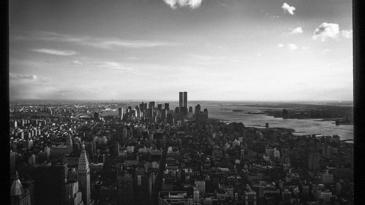 Black and white aerial image of Manhattan with the iconic Twin Towers.