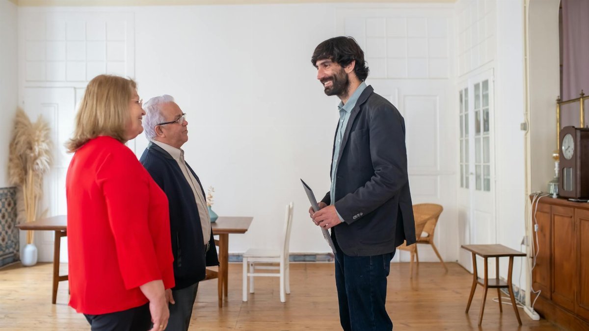 Three adults discussing business in a bright, modern office space.