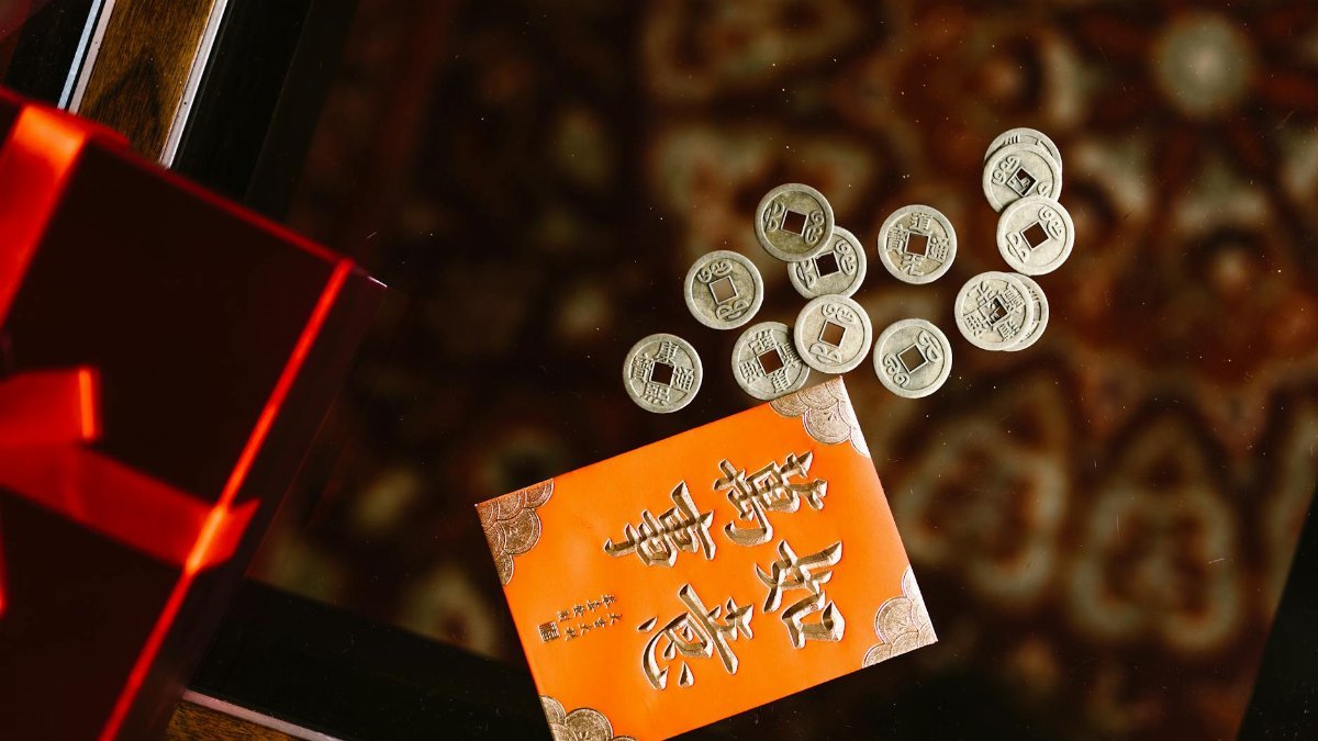 A traditional red envelope with Chinese coins, symbolizing prosperity for the New Year.