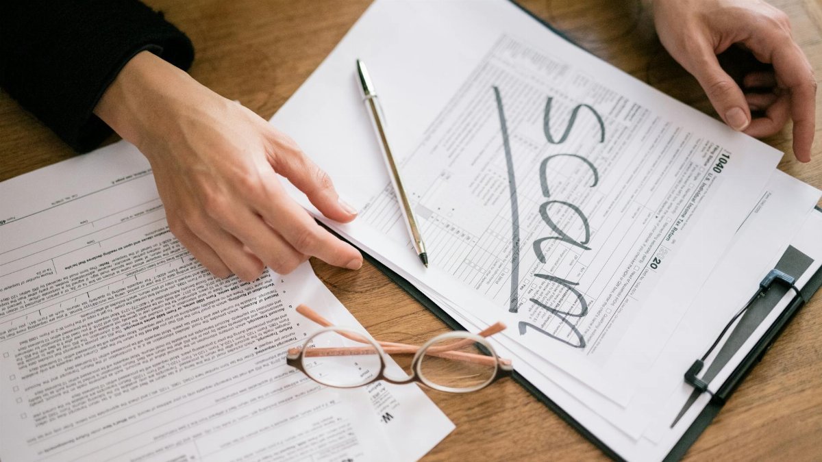 A close look at tax forms marked with scam, highlighting financial fraud risks.