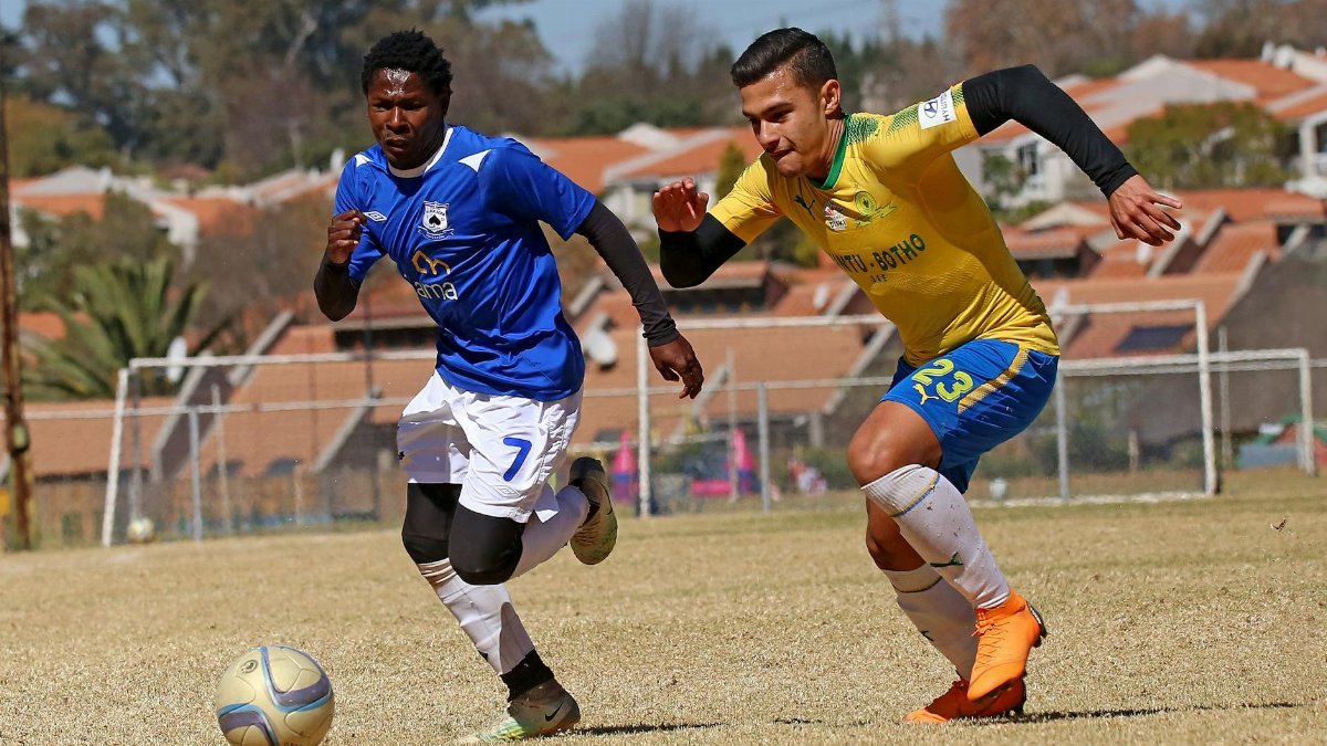 Two soccer players in action on a sunny field, vibrant competition.