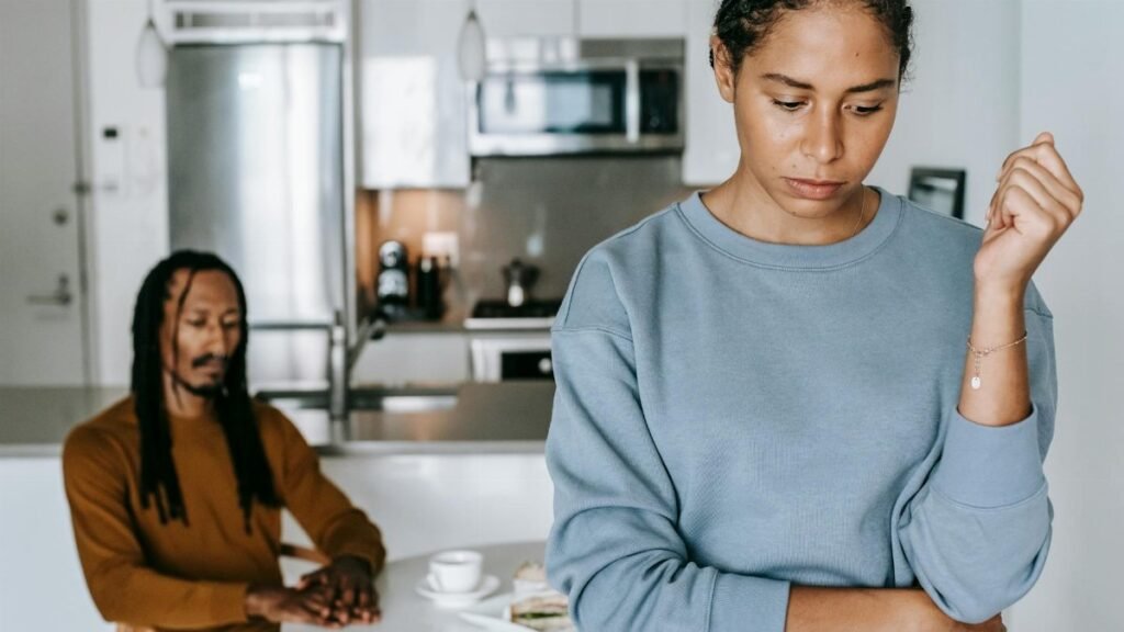 A couple in a kitchen experiencing a tense moment, reflecting on relationship issues.