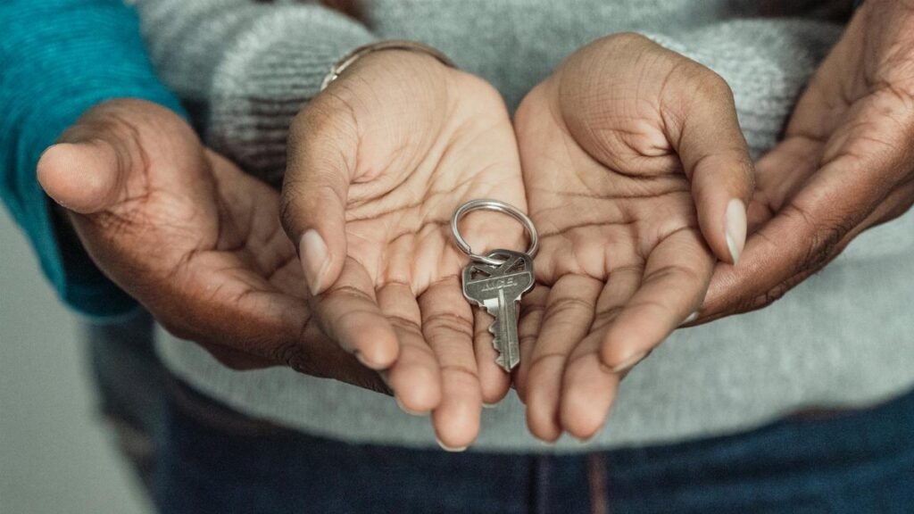Close-up of a couple sharing a key, symbolizing new home ownership.