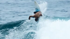 Surfer executing an acrobatic move on a wave in Brazil, showcasing skill and adventure.