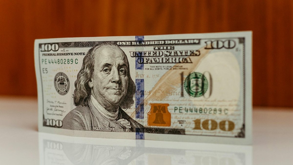 Detailed image of a US one hundred dollar bill featuring Benjamin Franklin.