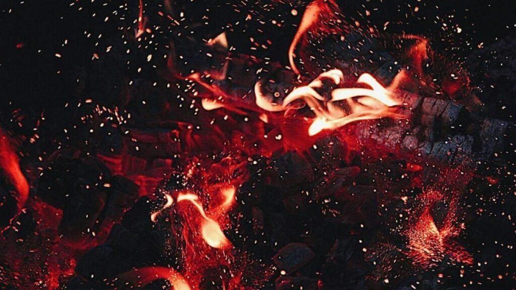 Dynamic close-up of red flames and sparks, showcasing intense heat and energy.
