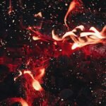 Dynamic close-up of red flames and sparks, showcasing intense heat and energy.