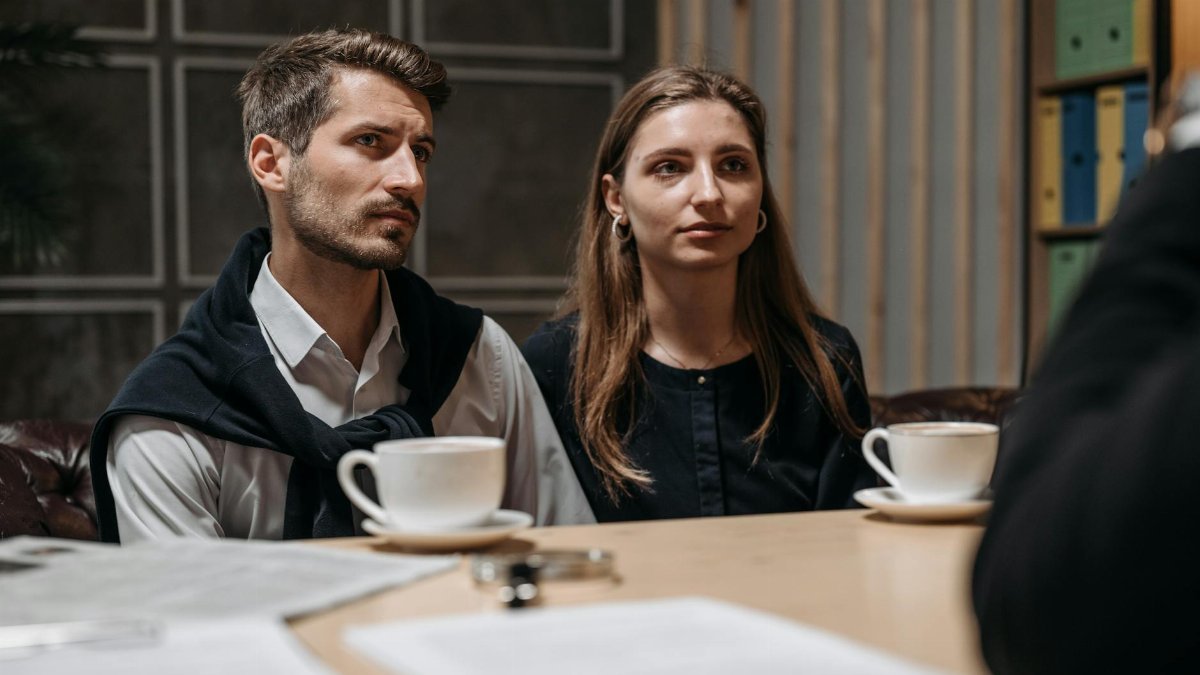 Business meeting with a couple engaging with a consultant in a modern office setting.