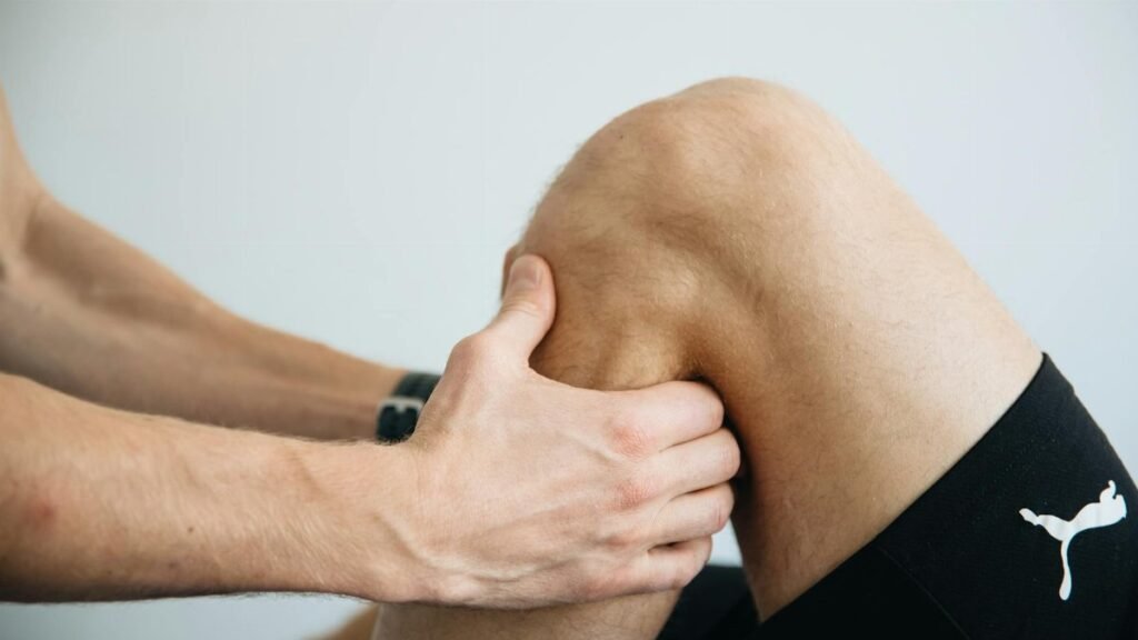 Detailed image of a physiotherapy session focusing on knee massage treatment.