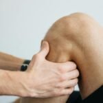 Detailed image of a physiotherapy session focusing on knee massage treatment.