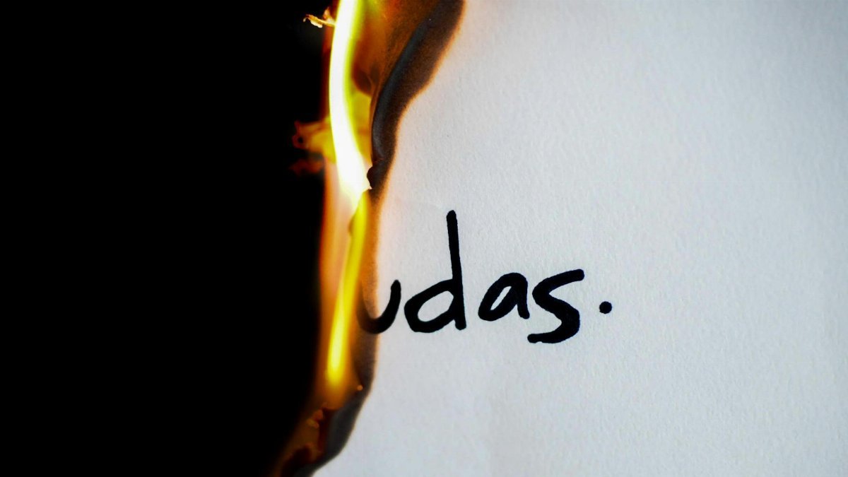 A piece of paper with handwritten text 'udas' partially engulfed in flames.