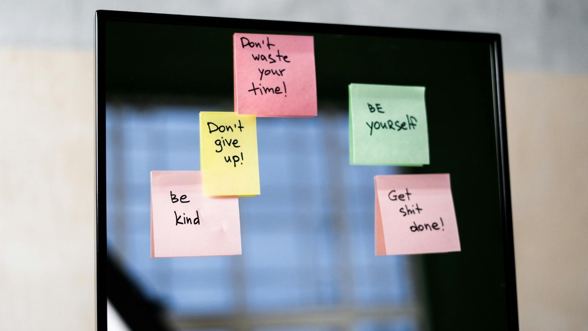 Colorful sticky notes on a mirror provide daily motivational messages and positivity reminders.