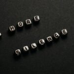 Minimalist black and white text art with message 'No More Silence' on a dark background.
