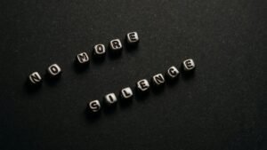 Minimalist black and white text art with message 'No More Silence' on a dark background.