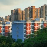 Urban landscape featuring high-rise residential buildings amidst lush greenery, captured during day.