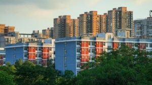 Urban landscape featuring high-rise residential buildings amidst lush greenery, captured during day.