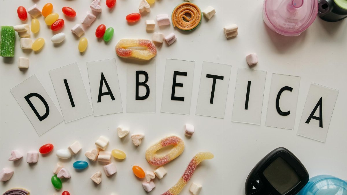 Close-up of candies and diabetes-related items on a white surface, featuring the word 'DIABETICA'.
