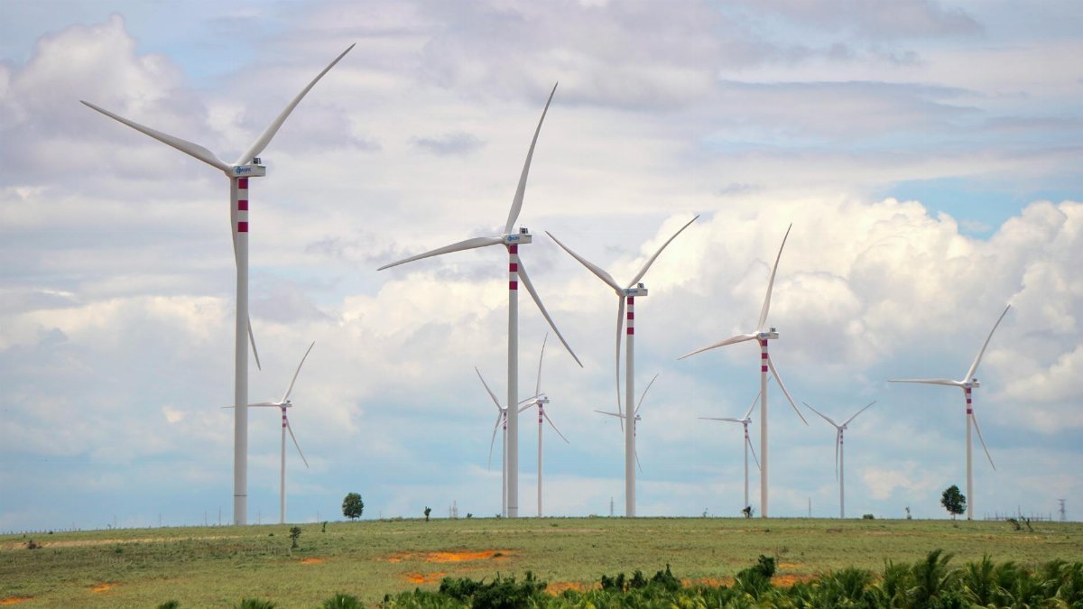 A scenic landscape featuring multiple wind turbines against a cloudy sky, symbolizing renewable energy.