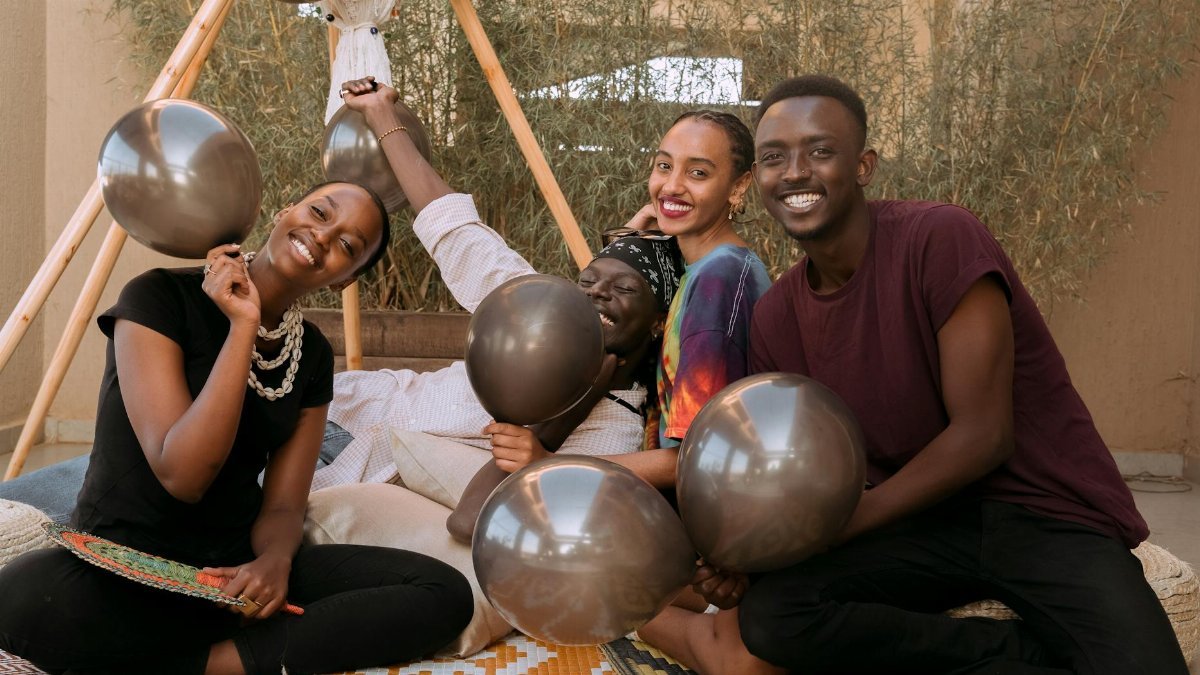 A lively outdoor gathering with friends celebrating with balloons and smiles.