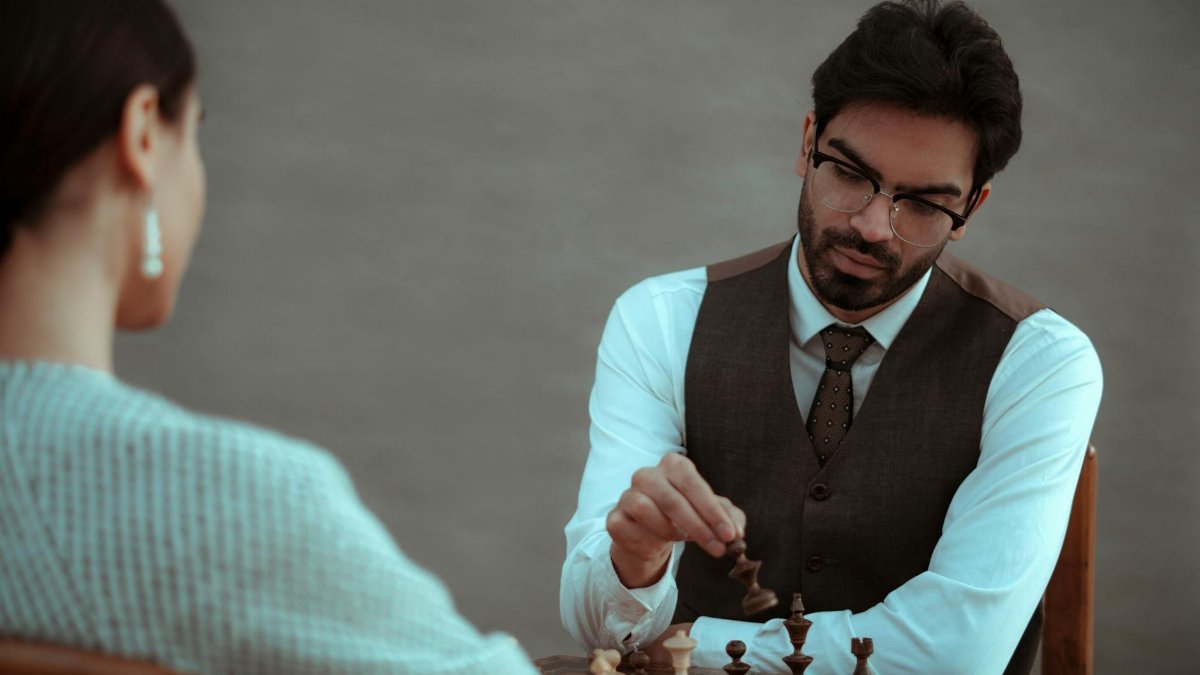 Two people engaged in a serious chess game, focusing on strategy and skill.