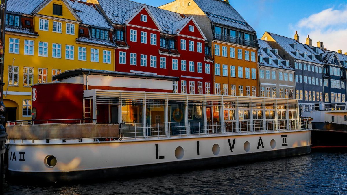 Vibrant buildings and canal boat at Nyhavn, Copenhagen in winter.
