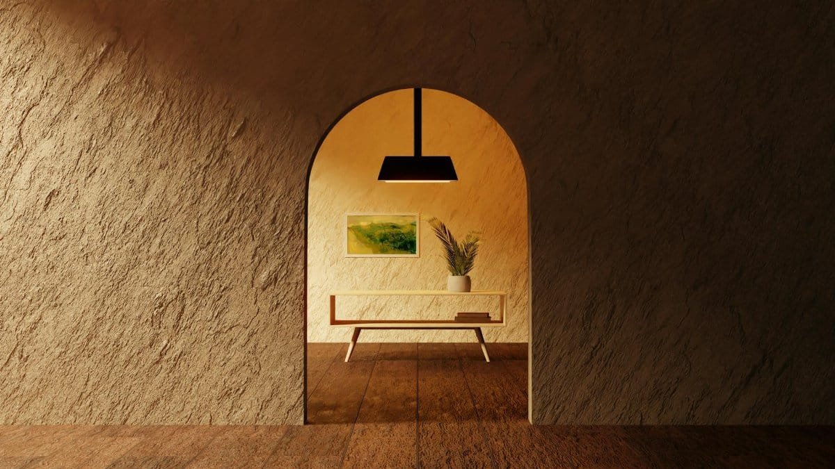 A cozy minimalist room with textured walls and a modern archway, illuminated by warm lighting.