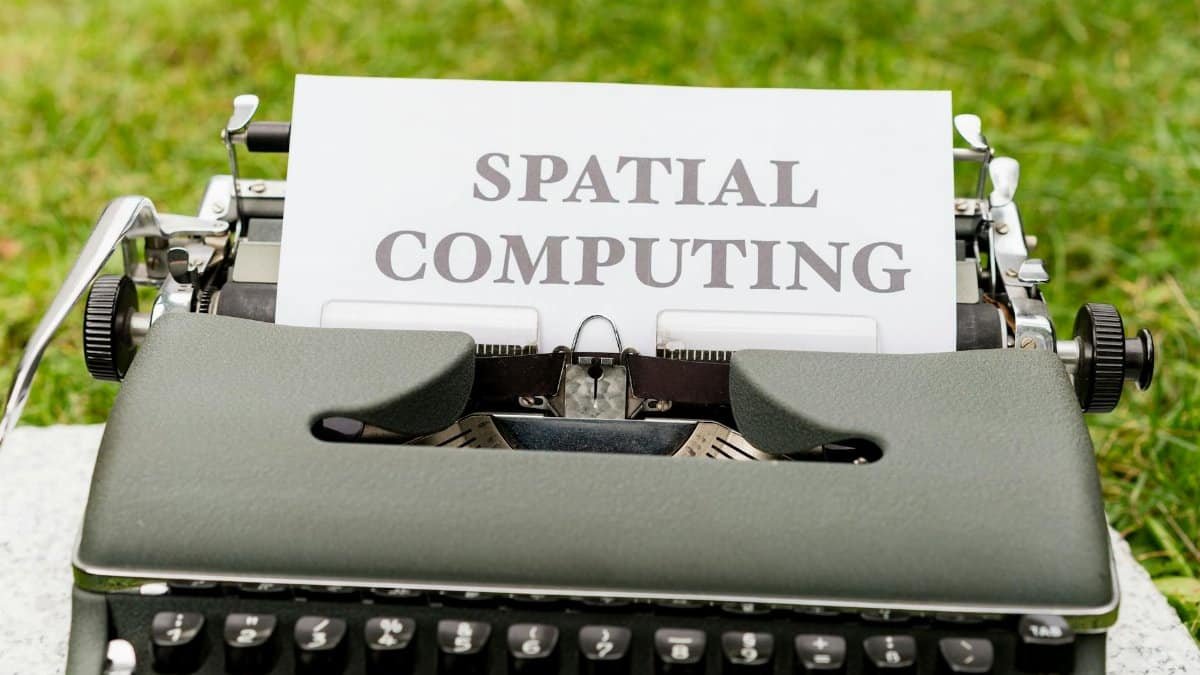 A vintage typewriter displays 'Spatial Computing' on paper in an outdoor setting.