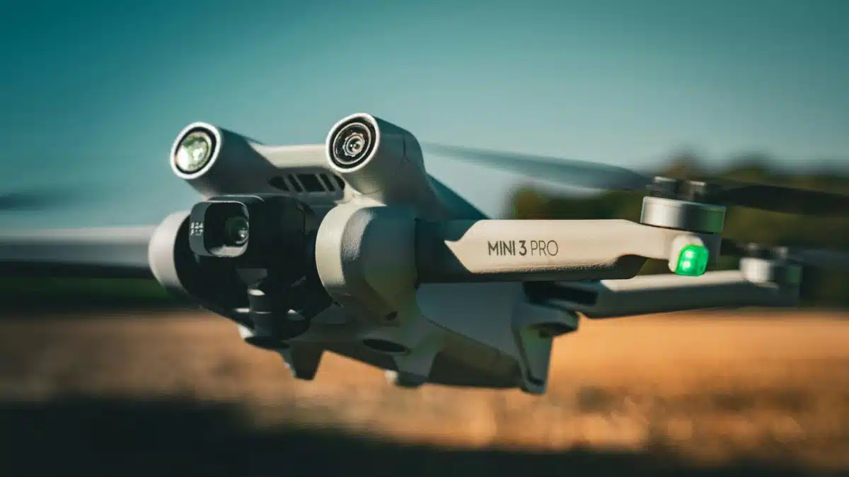 Detailed shot of a Mini 3 Pro drone flying outdoors, showcasing its camera and design.