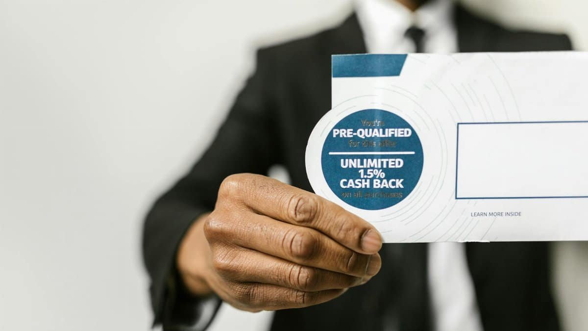 Close-up of a businessman holding an envelope with a pre-qualified cash back offer.