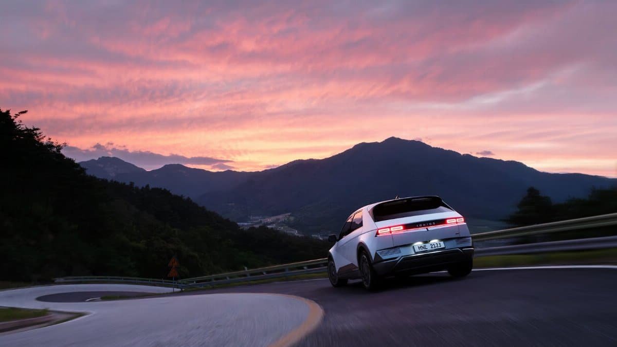 Hyundai Ioniq 5 on a mountain road during a stunning sunset, showcasing modern electric mobility.