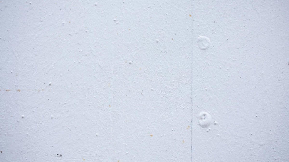 Textured backdrop of wall with spots and dots on shabby light blue surface