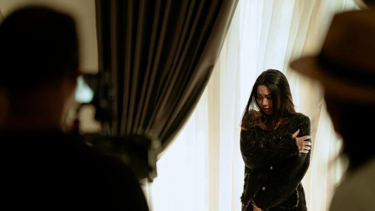A woman actor performing a scene indoors, captured with dramatic lighting and intense emotion.
