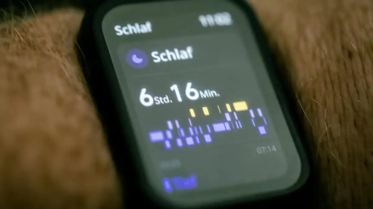 Close-up of a smartwatch displaying sleep tracking data in German.