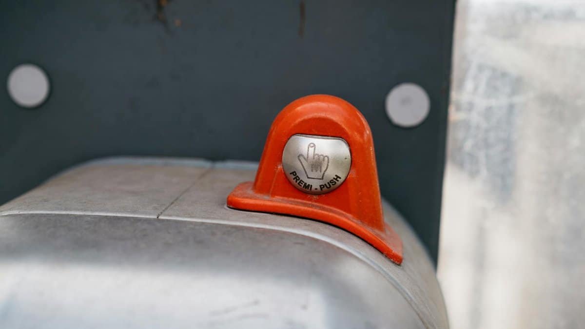 A detailed image of an orange industrial push button labeled 'Premi-Push.'