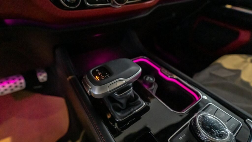 Close-up of a luxury car's gear shift with ambient lighting in Dubai.