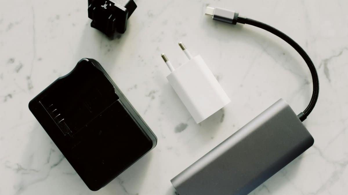 A collection of electronic adapters and cables on a marble surface, showcasing tech essentials.