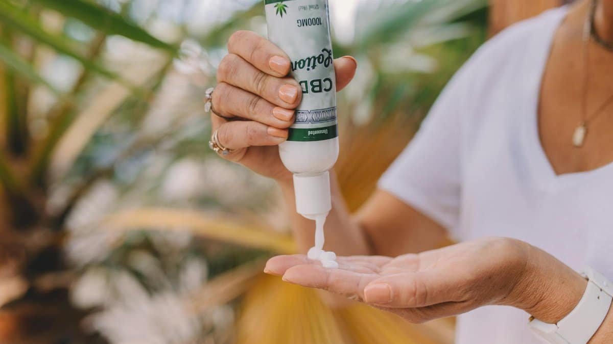 Hand applying CBD lotion outdoors, promoting relaxation and skincare benefits.