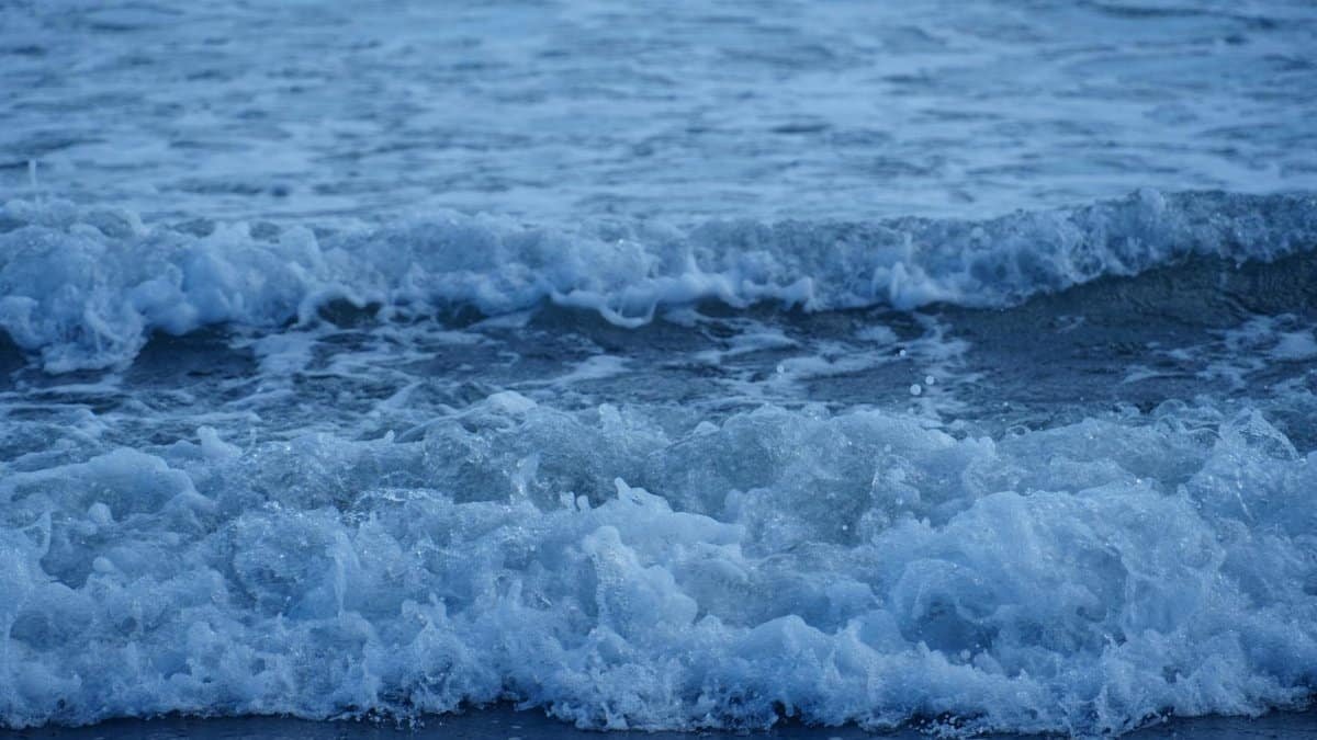 Dramatic ocean waves breaking on the shore with foamy splashes, capturing nature's power.