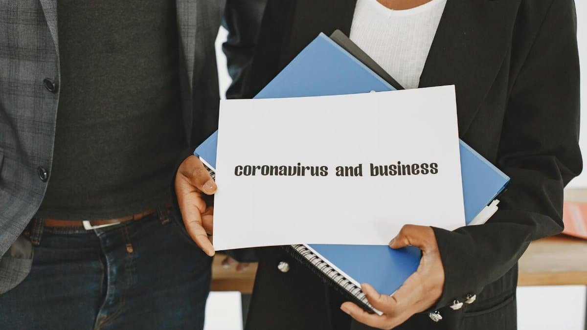 Business professionals hold a document about coronavirus impact with formal attire visible.