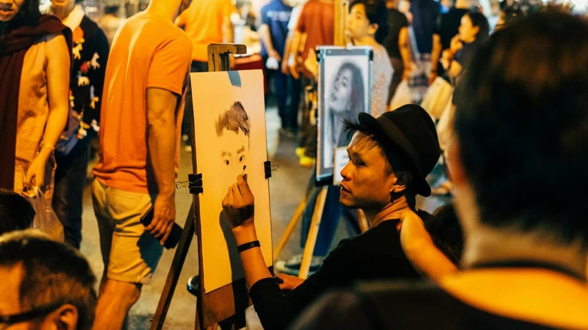 An artist captures a portrait at the bustling Chiang Mai Night Market, Thailand.